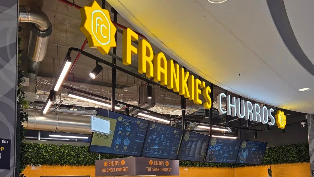 Verkaufstheke von Frankie's Churros im Milaneo, beleuchtetes Schild, Lichtschienen und Menü-Displays